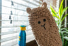 crochet llama dusting mitt being used for cleaning