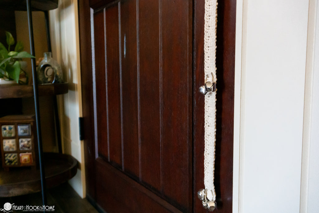 dog using potty training bell hanging on door